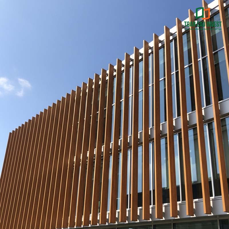 A high-rise glass-clad building incorporating wood-effect Vertical Sun Louvers, bringing a warm aesthetic and a harmonious connection with the natural environment.