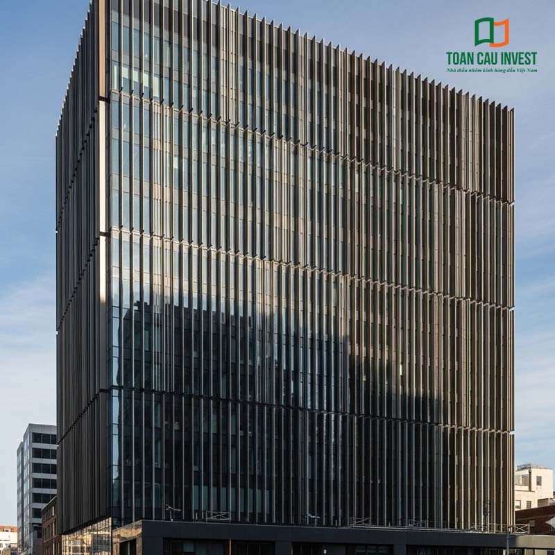 An office tower incorporating Vertical Sun Louvers in aluminum and glass across the entire façade, enhancing solar shading performance and architectural aesthetics.