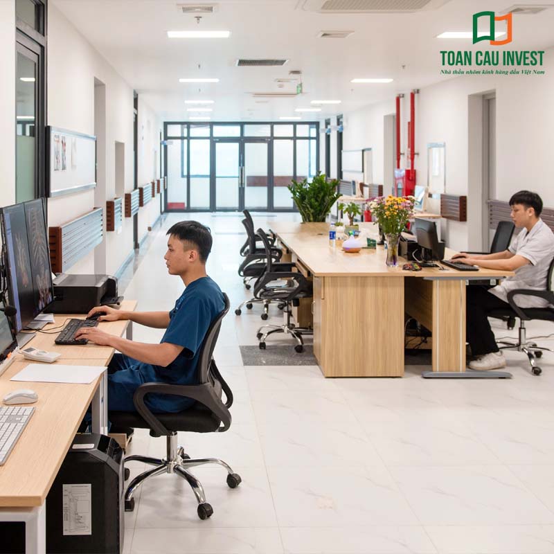 Hành lang bệnh viện sử dụng lan can kính và hệ cửa nhôm kính đồng bộ – giải pháp nhôm kính cho bệnh viện đảm bảo an toàn, thông thoáng và tối ưu quy trình vận hành.