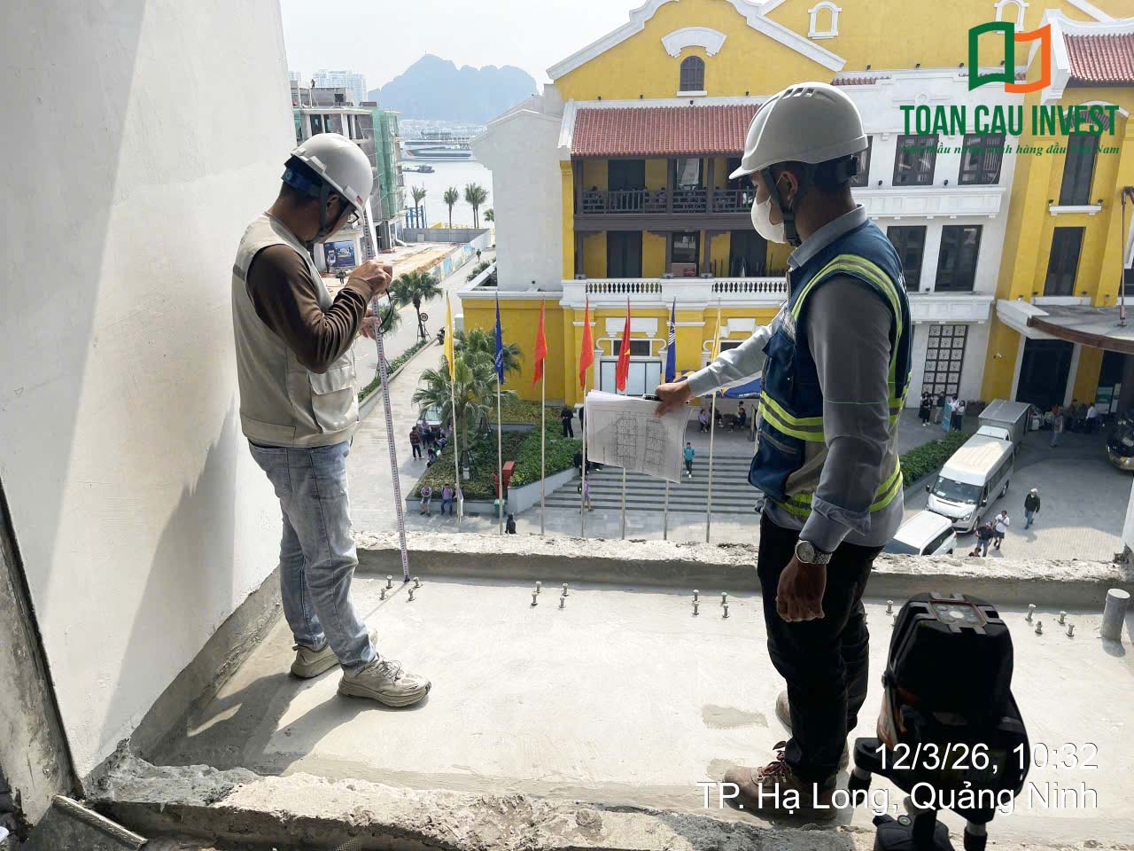 Hình ảnh nhôm kính thi công tại Sora Bay - Hạ Long, kỹ sư đo đạc kích thước thực tế tại ban công để chuẩn bị lắp đặt lan can kính và cửa nhôm kính.