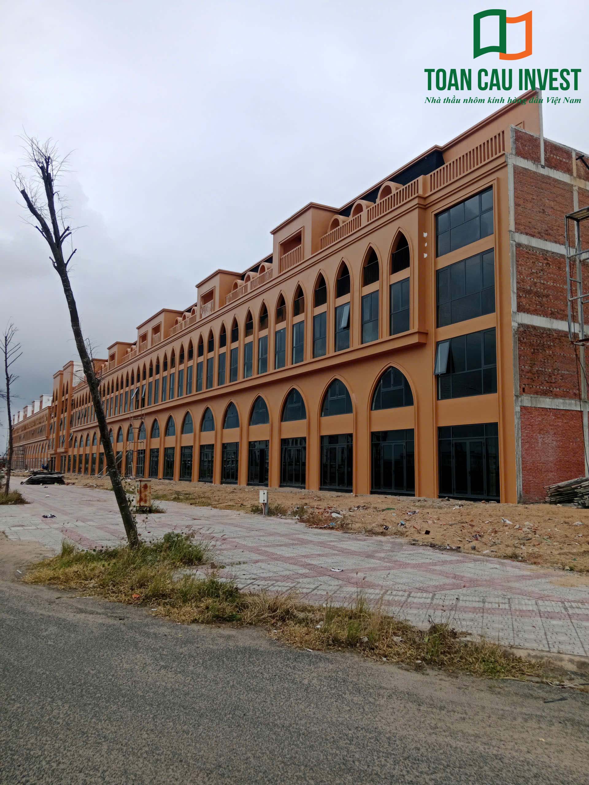 Hình ảnh nhôm kính thi công tại Lynn Times Riverside – tổng thể dãy shophouse với hệ cửa nhôm kính lớn đang trong giai đoạn hoàn thiện mặt ngoài.