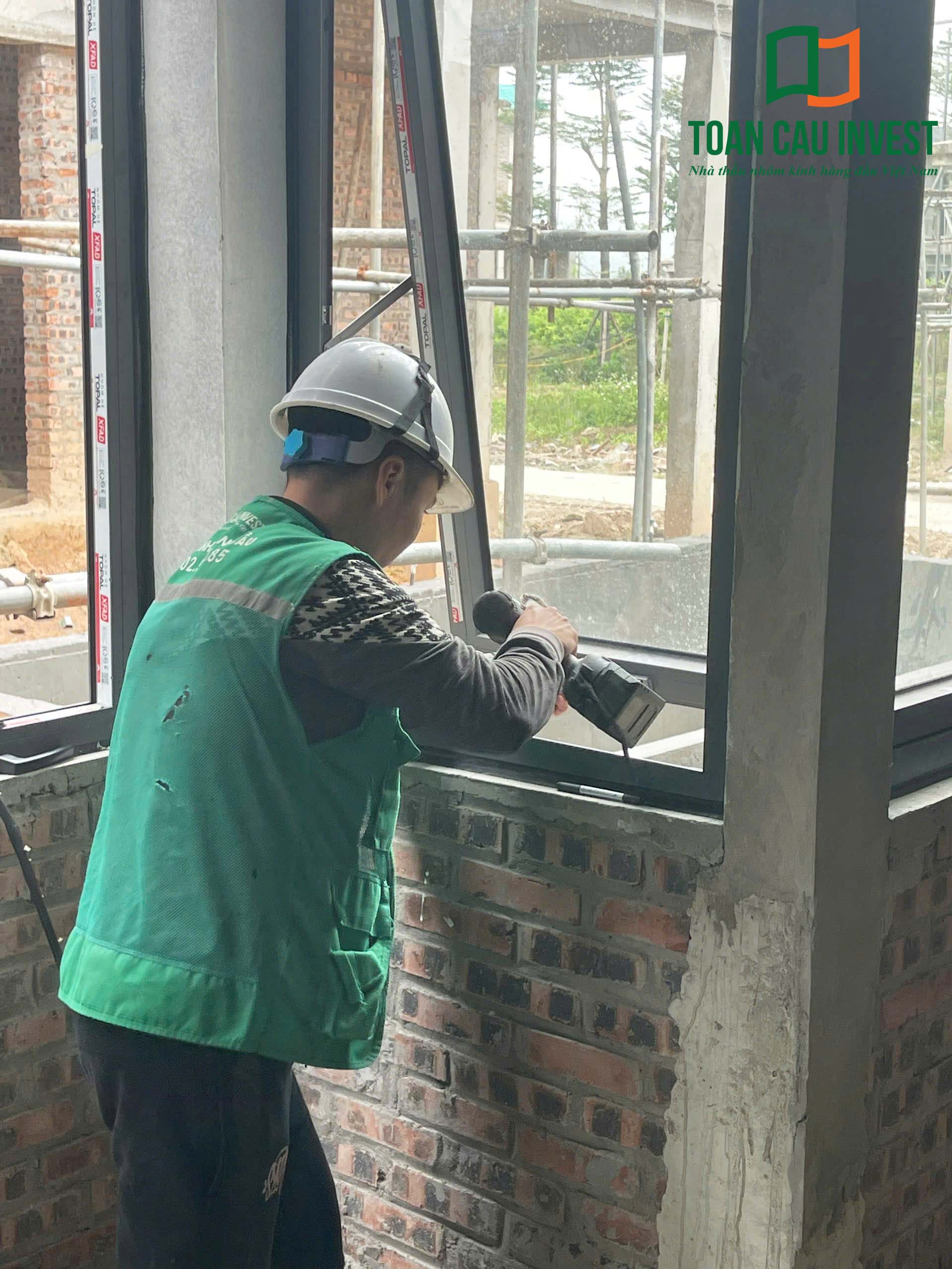 Hình ảnh nhôm kính thi công tại Wyndham Lynn Times - Thanh Thủy, Phú Thọ – kỹ thuật viên kiểm tra và bắt vít cố định khung cửa nhôm kính.
